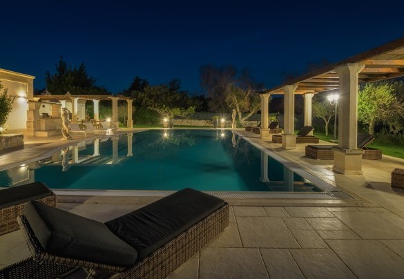 La vista di notte della piscina, i gazebo e i comodi lettini prendisole – Villa La Dolce Vita