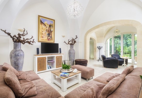 Soggiorno con grandi divani e un’arcata in pietra – Villa La Dolce Vita