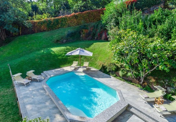 The pool edge and the solarium area are paved and equipped with sunbeds, director's chairs and a large umbrella - Villa La Dolce