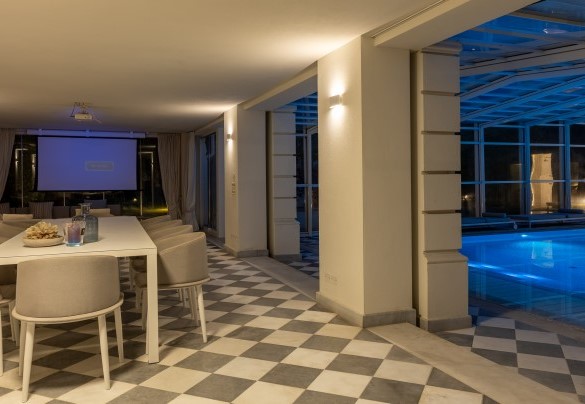 Veranda con porte vetrate e attrezzata a zona pranzo, area relax, collegata al tunnel di copertura della piscina, a diventare uno spazio chiuso e godibile anche in inverno - Villa La Perla Bianca 
