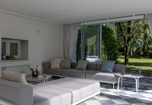 Veranda con porte vetrate e attrezzata a zona pranzo, area relax, collegata al tunnel di copertura della piscina, a diventare uno spazio chiuso e godibile anche in inverno - Villa La Perla Bianca 