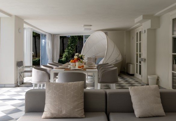 Veranda con porte vetrate e attrezzata a zona pranzo, area relax, collegata al tunnel di copertura della piscina, a diventare uno spazio chiuso e godibile anche in inverno - Villa La Perla Bianca 