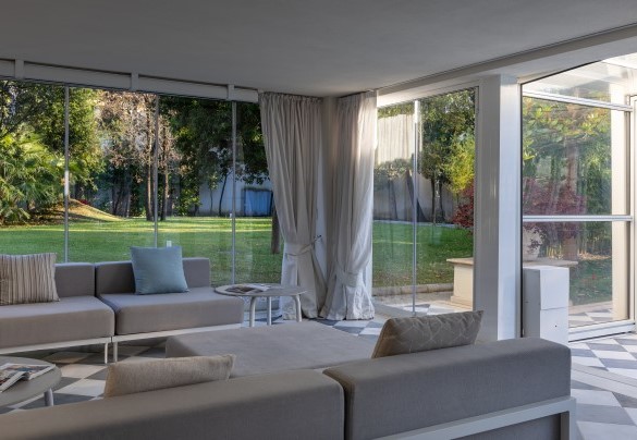 Veranda con porte vetrate e attrezzata a zona pranzo, area relax, collegata al tunnel di copertura della piscina, a diventare uno spazio chiuso e godibile anche in inverno - Villa La Perla Bianca 