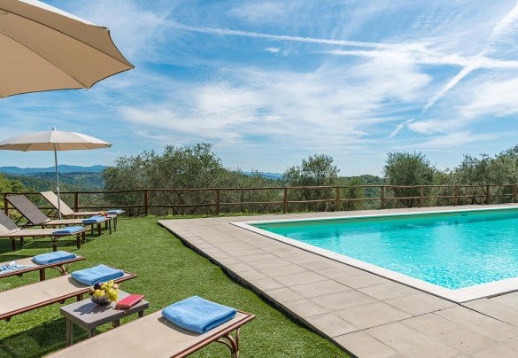 The pool, bordered in basalt, furnished with sunbeds and umbrellas, surrounded by the lush park – Villa La Poiana 10