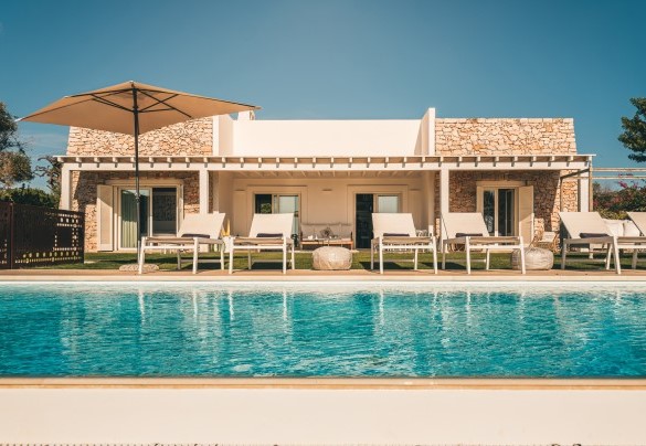La piscina è circondata da un perimetro di mattoni chiari dove sono adagiati i lettini fronte mare – Villa La Pupazza