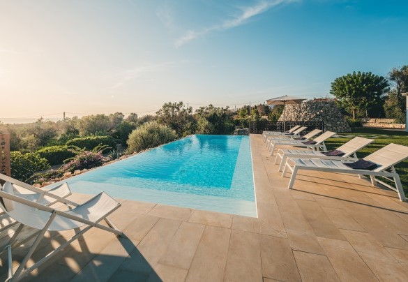 La piscina a sfioro si protende verso il mare in un profumato contesto dove trovano spazio diversi angoli finemente arredati – Villa la Pupazza