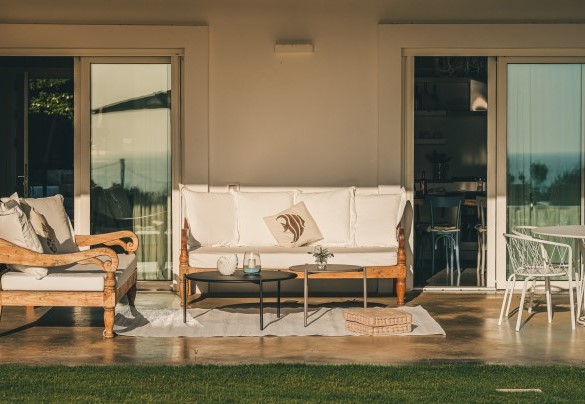 Il patio arredato con un meraviglioso salotto in legno, è una delle zone esterne più godibili, dove trascorrere del tempo in relax godendo di una splendida vista della piscina e del mare – Villa La Pupazza