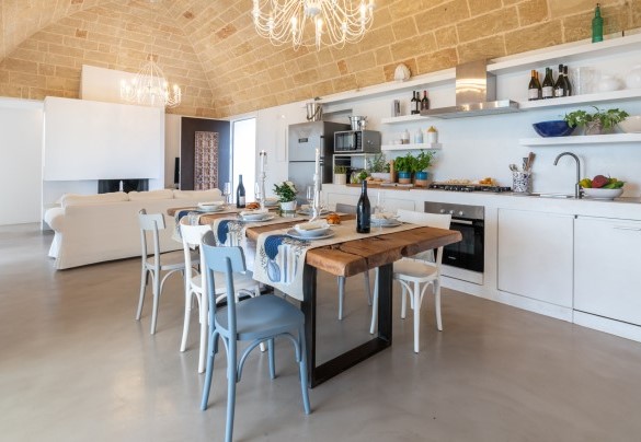 Spaziosa cucina moderna sapientemente accessoriata, con grande tavolo da pranzo di design in legno di ulivo -Villa La Pupazza