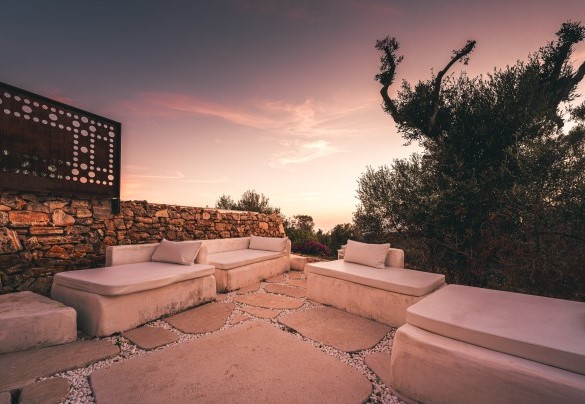 Non lontano dalla piscina si sviluppa una zona relax con divanetti in pietra, realizzata accanto ad una splendida Pajara originale che vi fa da cornice – Villa la Pupazza