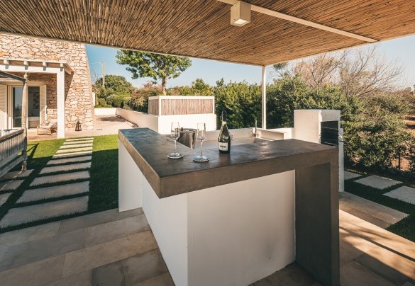 L’angolo bar è realizzato sotto il pergolato a completamento della zona pranzo esterna, impreziosito da un pratico barbecue in muratura – Villa la Pupazza