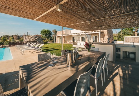 La comoda zona pranzo a ridosso della piscina, è caratterizzata da un grande tavolo in pietra e impreziosita da una tettoia e un angolo bar in muratura con barbecue – Villa La Pupazza