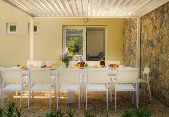 Di fronte all’ingresso principale della villa siamo accolti nell’area esterna piastrellata, organizzata con gazebo, tavolo e sedie – Villa Laconella
