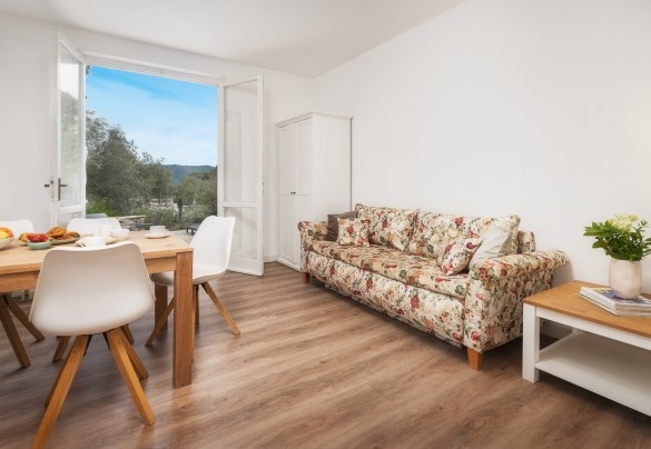 Zona giorno n. 2 al piano terra con tavolo, divano e TV – Villa Laconella
