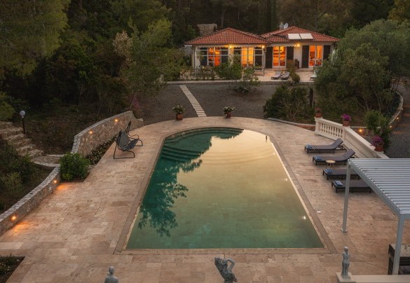 A lato della piscina, risalendo una scala in pietra che attraversa la vegetazione, si giunge ad un piccolo cancello che ci porta sulla strada che arriva fino alla spiaggia di Lacona – Villa Laconella