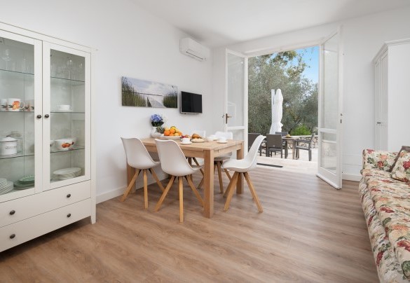 Zona giorno n. 2 al piano terra con tavolo, divano e TV – Villa Laconella