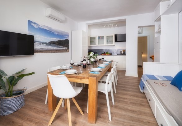 Zona giorno n. 1 al piano terra con angolo cottura, tavolo, divano e TV – Villa Laconella