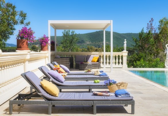 La zona solarium con pavimentazione in travertino ed arredata con lettini prendisole e con un bel gazebo allestito con divanetti – Villa Laconella