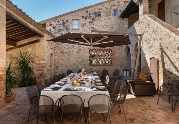 The outdoor dining table is placed in the courtyard - Villa Le Beringhe