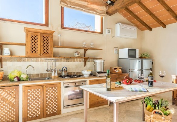La cucina attrezzata con uscita nella corte – Villa Le Chiarne