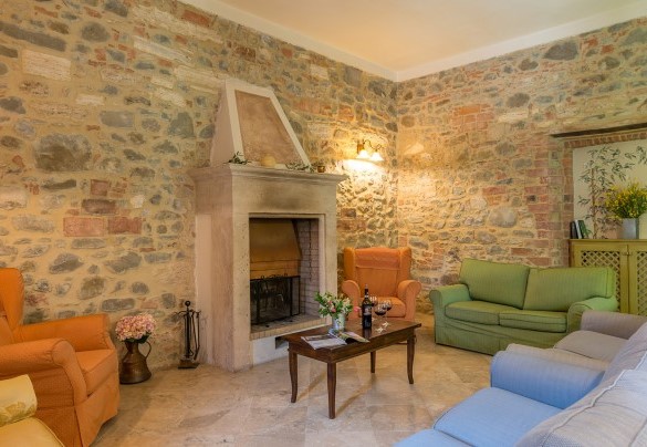 Il salotto con caminetto e Tv satellitare – Villa Le Chiarne 
