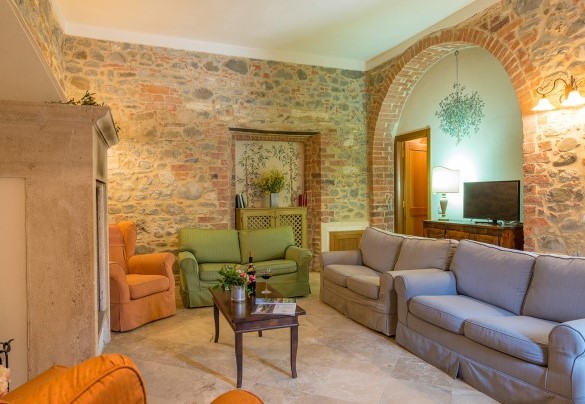 Il salotto con caminetto e Tv satellitare – Villa Le Chiarne 