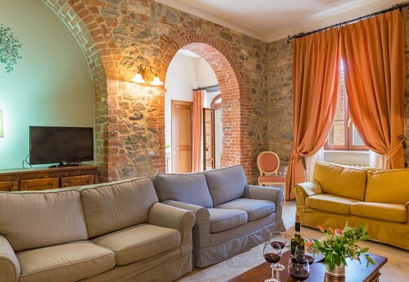 Il salotto con caminetto e Tv satellitare – Villa Le Chiarne 
