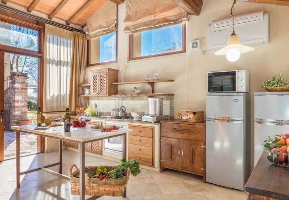 La cucina attrezzata con uscita nella corte – Villa Le Chiarne 
