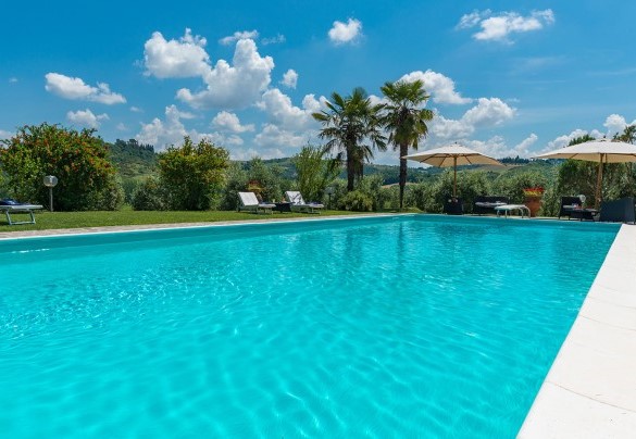 Il parco che cinge la piscina, affacciato su verdi paesaggi – Villa Le Focaie 