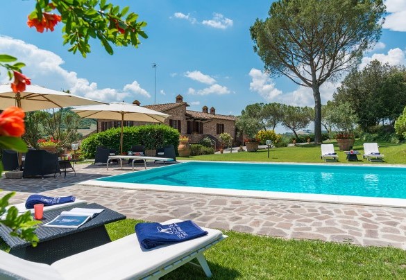 La piscina è adagiata al centro di una estesa superficie a prato, di fronte al casale – Villa Le Focaie 
