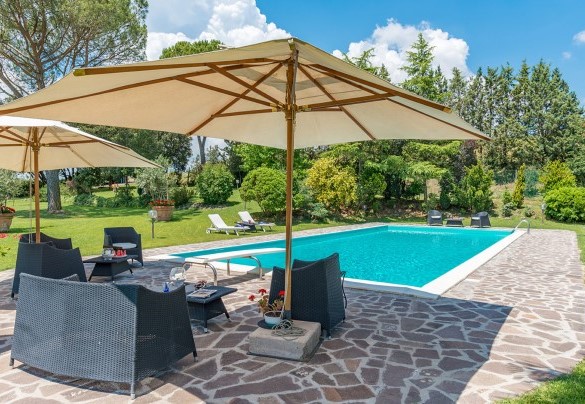 La piscina bordata accoglie comodi lettini all’ombra – Villa Le Focaie 