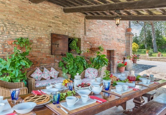Il portico ombreggia il tavolo preparato per colazioni all’aperto – Villa Le Focaie 