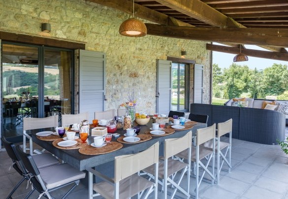 The outdoor dining area under the portico, set up with table, chairs and sofas - Villa Le Fontane
