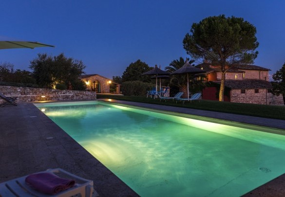 The beautiful illuminated pool and the house in the background - Villa Le Logge 