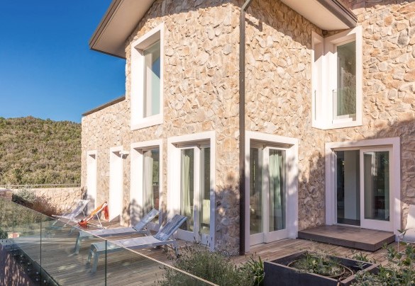 L’elegante area prendisole pavimentato in tek, arredata con lettini, ombrellone e una doccia con acqua calda e fredda - Villa Le Mandrie