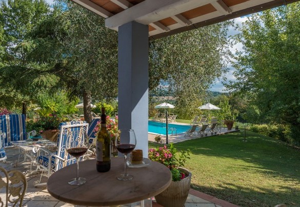 Il portico con divani e tavolini, che si sviluppa davanti alla dependance e si affaccia sulla piscina – Villa Leonardo