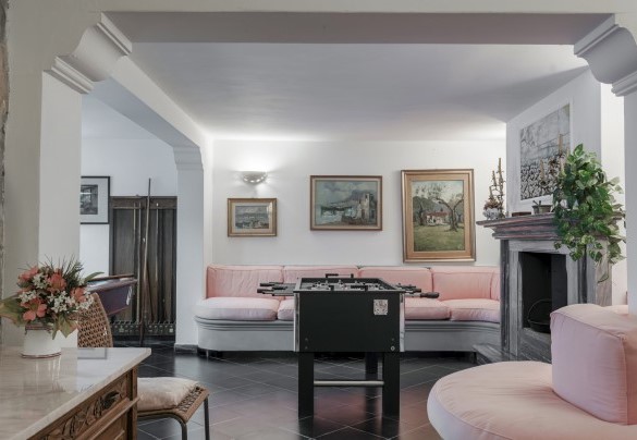 Dalla sala di ingresso del primo piano, una scala scende (13 gradini) al pianterreno che comprende un grande locale open space con un angolo soggiorno con camino, un biliardo, un calciobalilla e un tavolo da gioco - Villa Liberty Albisola