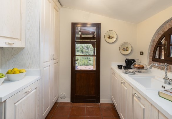 La cucina di servizio, dove è a disposizione anche la lavatrice. La cucina di servizio accede ad un terrazzo piastrellato – Villa Loredana