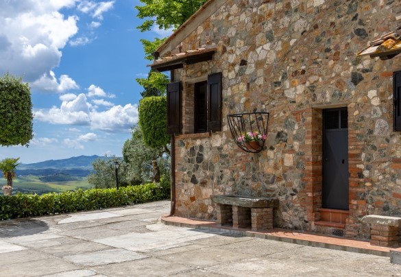 The stone area surrounding the villa is embellished with bowls of colourful flowers and bordered largely by hedges – Villa Loredana