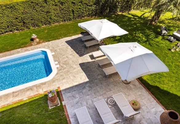 The pool with the solarium area with sunbeds and umbrellas – Villa Luigina