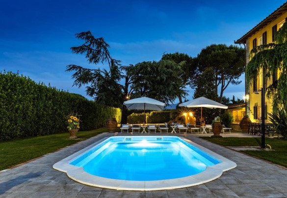 The pool with the solarium area illuminated at sunset – Villa Luigina