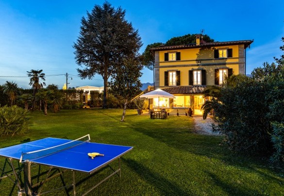 The tennis table immersed in the greenery of the villa illuminated at sunset – Villa Luigina