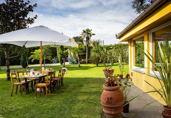 The outdoor dining shaded by an umbrella and by the veranda – Villa Luigina