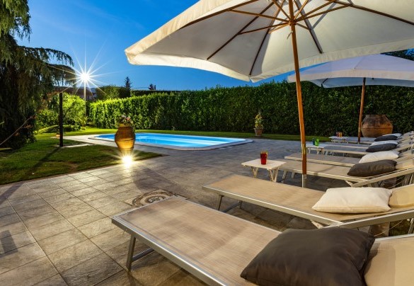  The pool with the solarium area illuminated at sunset – Villa Luigina
