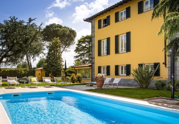 The pool with the solarium area with sunbeds and umbrellas – Villa Luigina