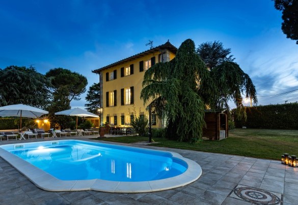 The pool with the solarium area illuminated at sunset – Villa Luigina