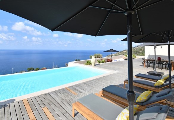 La terrazza pavimentata circonda la villa ed ospita eleganti lettini – Villa Luna