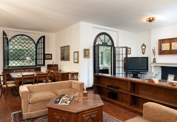 The large living room with dining area, TV corner with fireplace (ornamental) and a sitting area with access to the veranda via French windows - Villa Manganelli