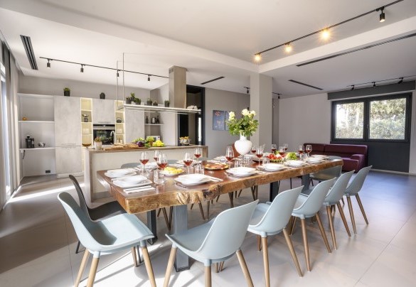 The dining table in the open-plan living connected by French windows to the pool area - Villa Maria Paradiso
