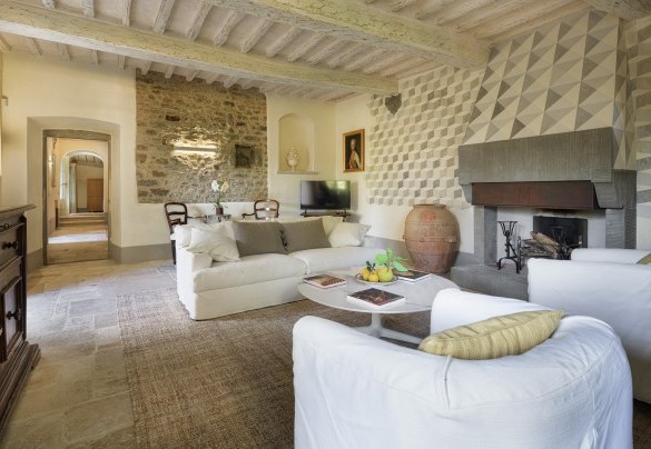 Salotto arredato con caminetto ornamentale, divano, poltrone e Smart TV - Villa Metelliano