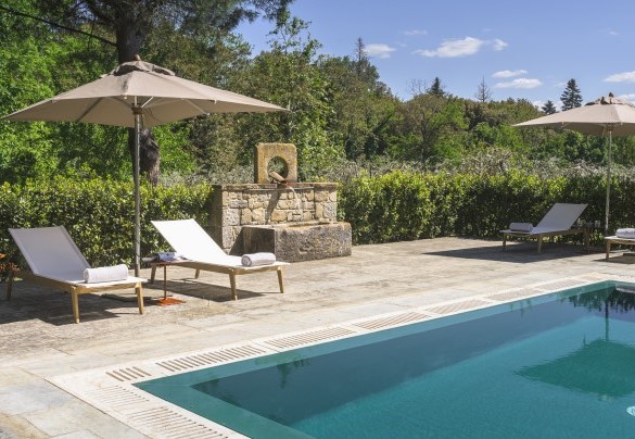 Il solarium, in pietra lastricata e prato, ospita lettini, ombrelloni e tavolini - Villa Metelliano